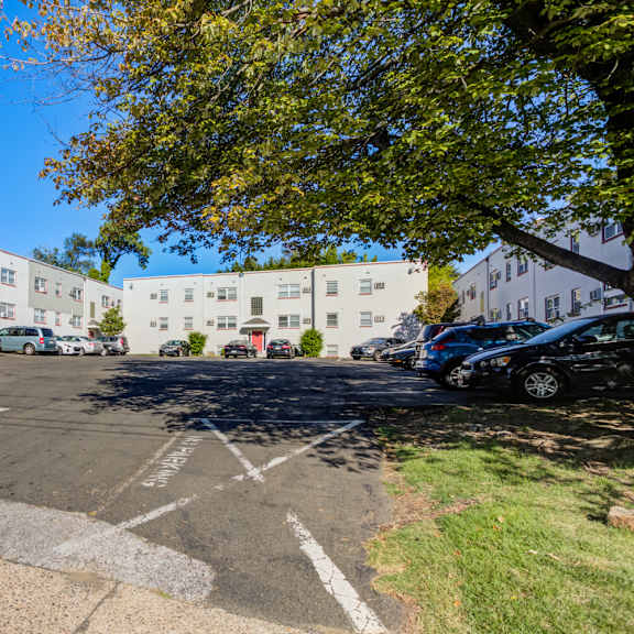 a parking lot with a sign that says "for charge place" is surrounded by trees and buildings.