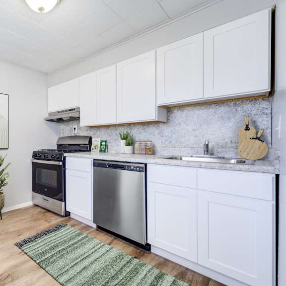 a kitchen with a refrigerator, oven, and sink.