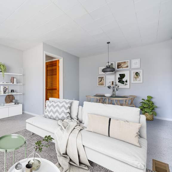 a living room with a white couch and a green table.