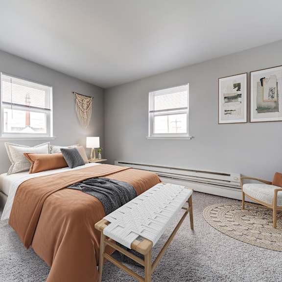 a bedroom with a bed, chair, and pictures on the wall.