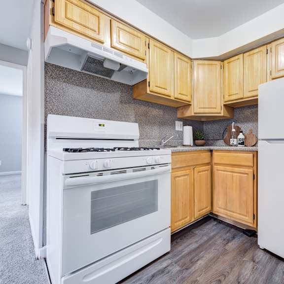 a kitchen with wooden cabinets and white appliances.