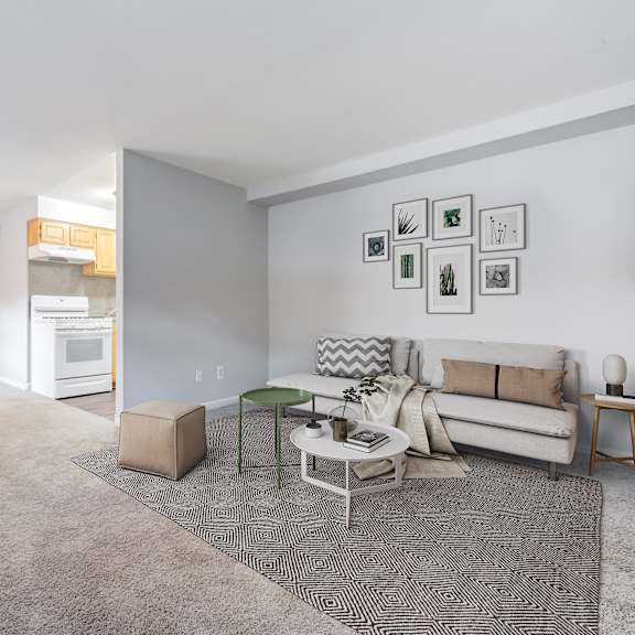 a living room with a grey carpet and a white sofa.