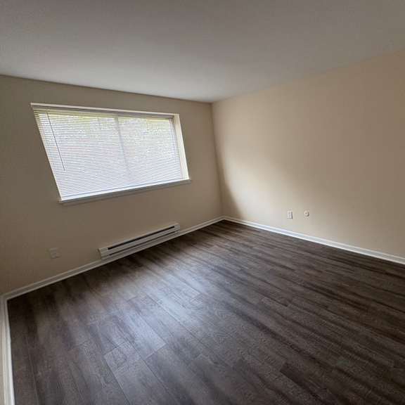 a room with a window and wooden flooring.