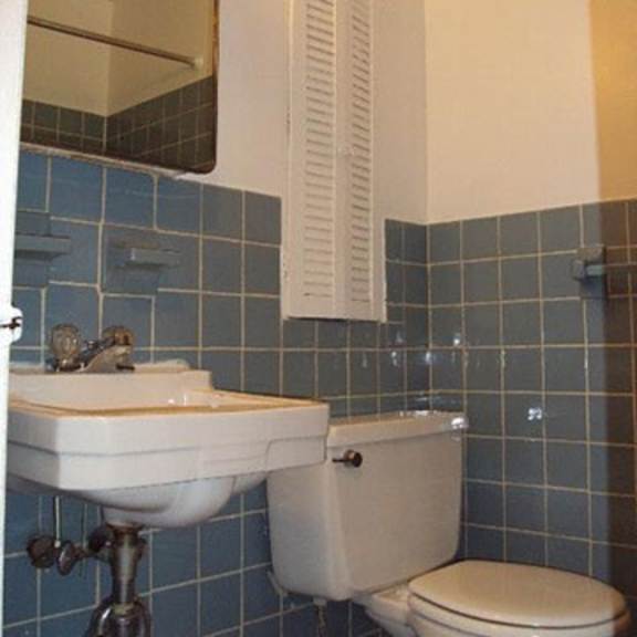 a bathroom with a toilet and a mirror