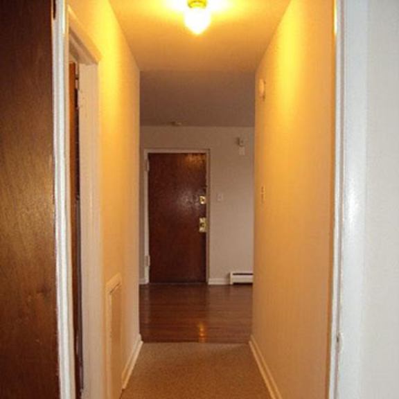 a hallway with a brown carpet and a door