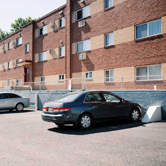 a parking lot filled with cars in front of a brick building