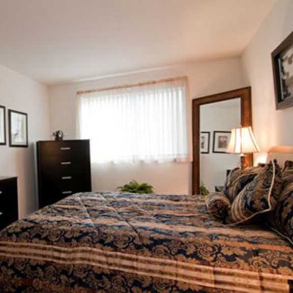 a bedroom with a bed and a dresser and a mirror