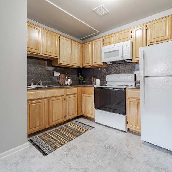 a kitchen with wooden cabinets and a white refrigerator.