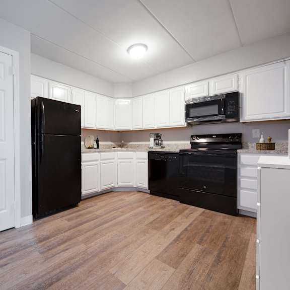 a kitchen with black appliances and white cabinets.