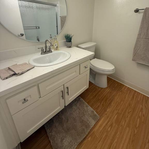 Thumbnail 5 of 6 A bathroom with a white sink and toilet.