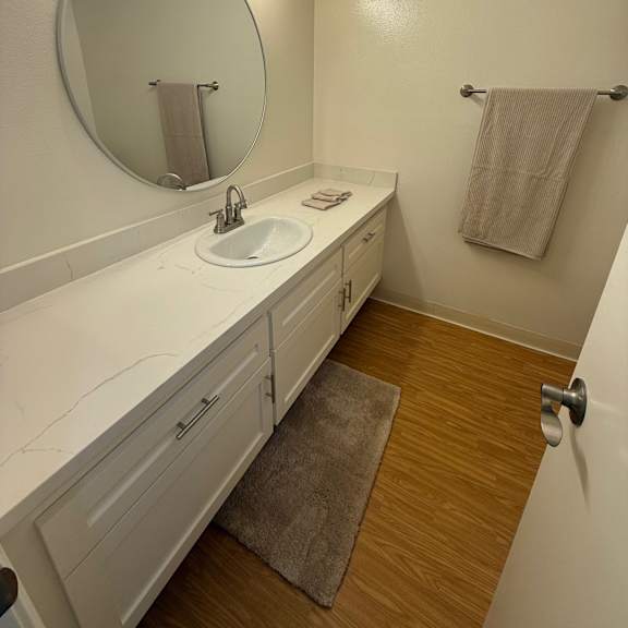Thumbnail 6 of 6 A bathroom with a sink, mirror, and towel rack.