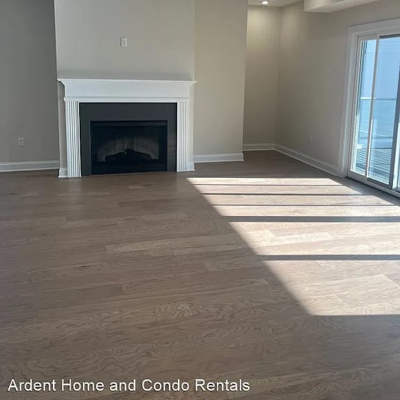 a living room with a fireplace and wooden floors