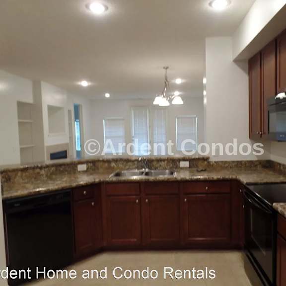 a kitchen with granite counter tops and black appliances