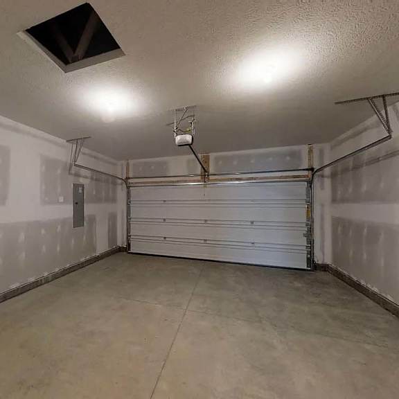 an empty garage with a white wall and a garage door