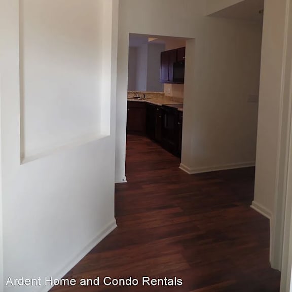 a view of a kitchen and a hallway with a hard wood floor