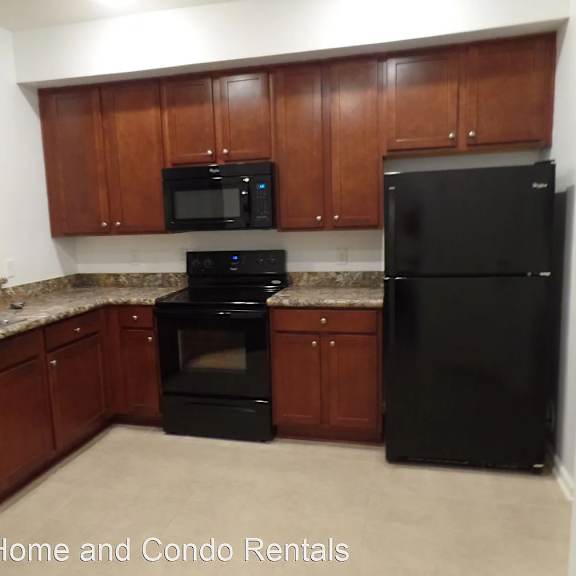 a kitchen with black appliances and wooden cabinets