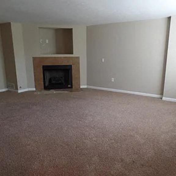 an empty living room with a fireplace in it