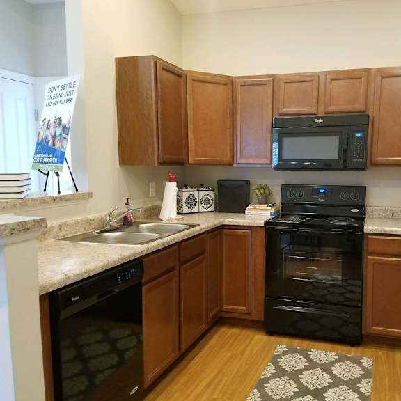 a kitchen with black appliances and wooden cabinets