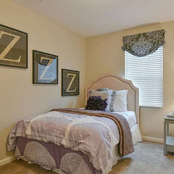a bedroom with a bed and some pictures on the wall