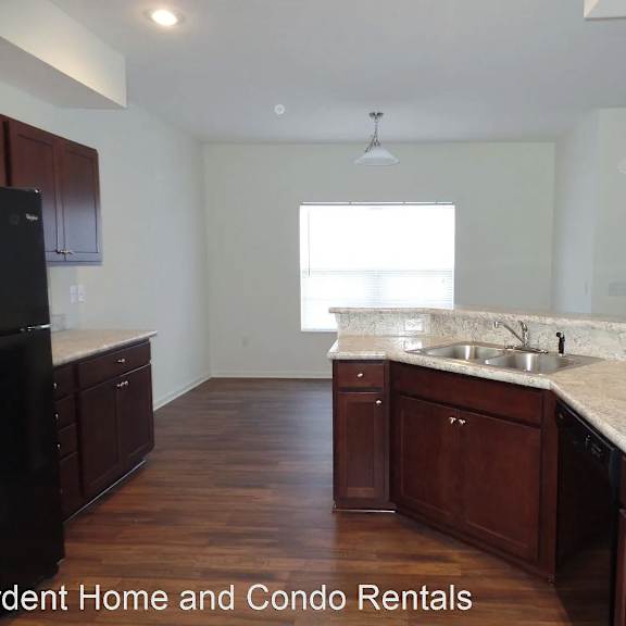 an empty kitchen with wooden cabinets and marble counter tops
