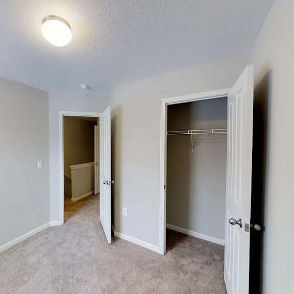 an empty bedroom with a closet and a door to a closet