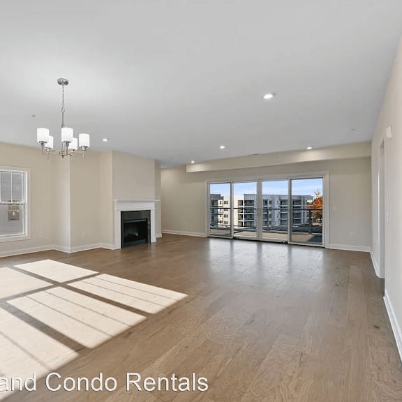 an empty living room with a fireplace and wooden floors
