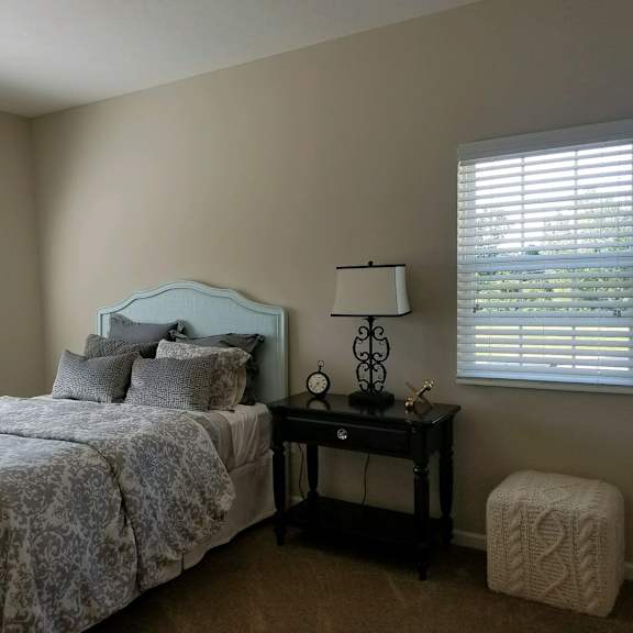 a bedroom with a bed and a nightstand and a window