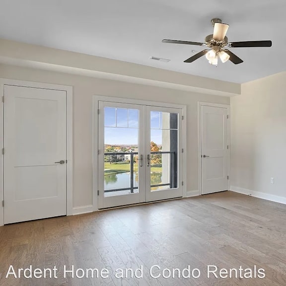 an empty living room with white walls and a ceiling fan
