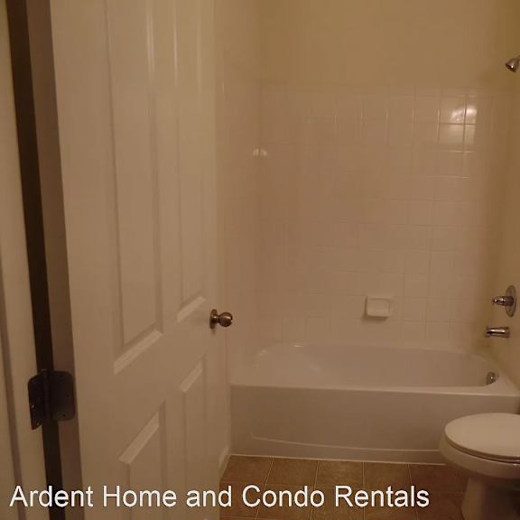 a white bathroom with a tub and a toilet
