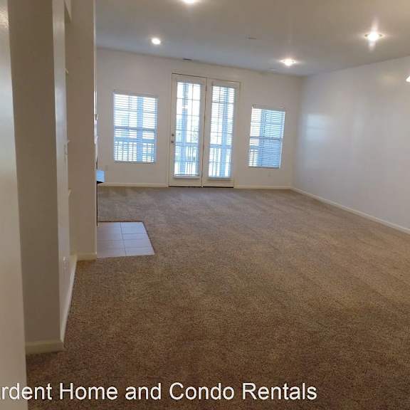 an empty room with a carpeted floor and windows