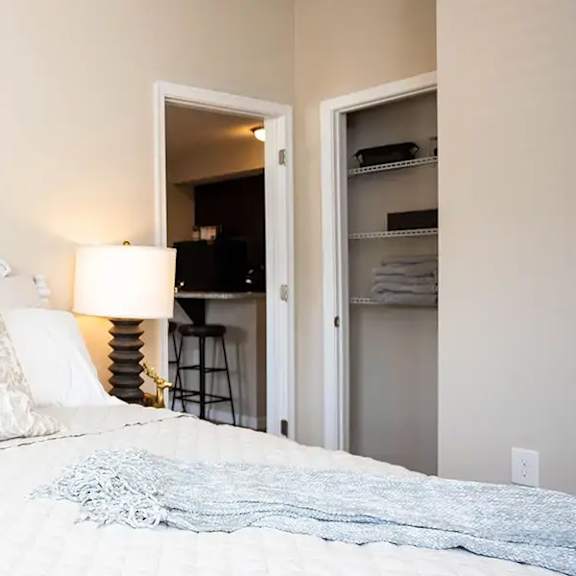a white bedroom with a bed and a closet