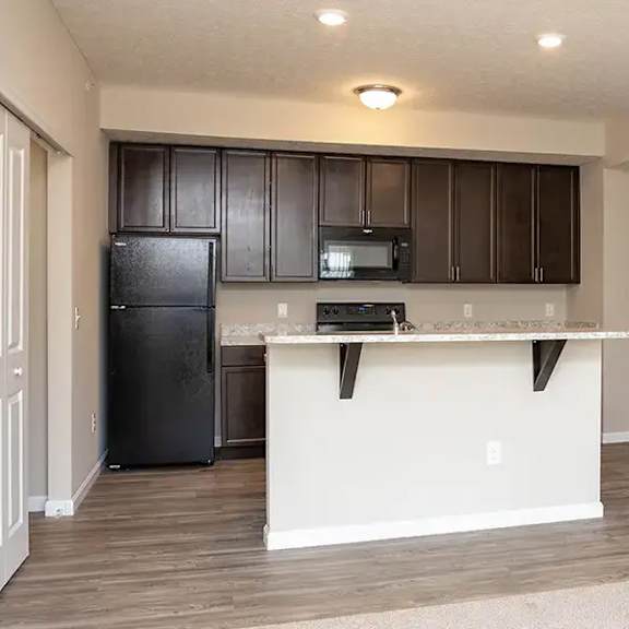 a kitchen with a counter and a black refrigerator