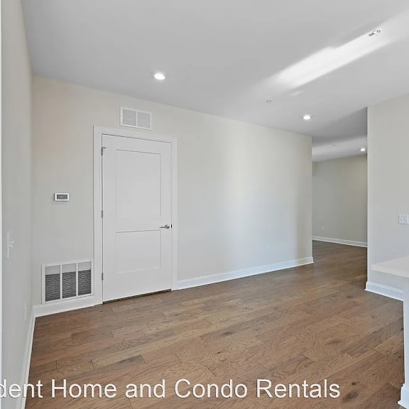 an empty room with white walls and a wooden floor