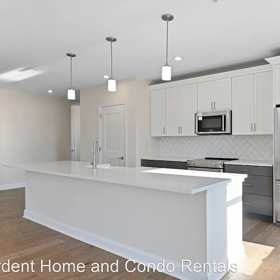 a white kitchen with white cabinets and stainless steel appliances