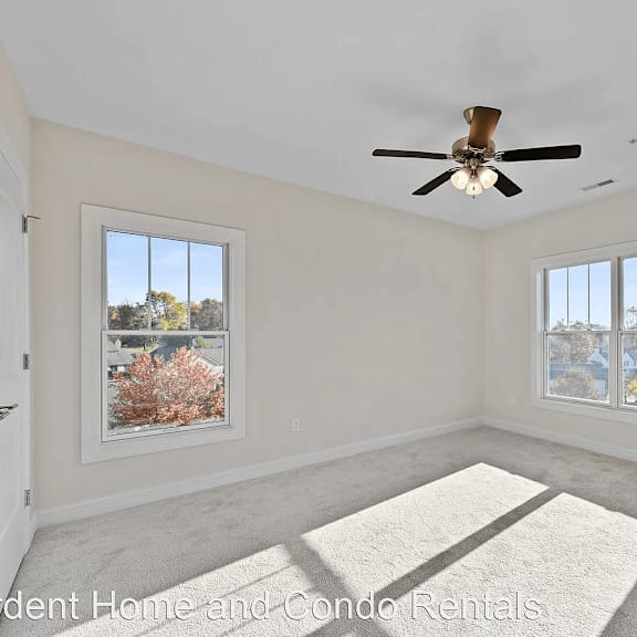 a empty room with a ceiling fan and windows
