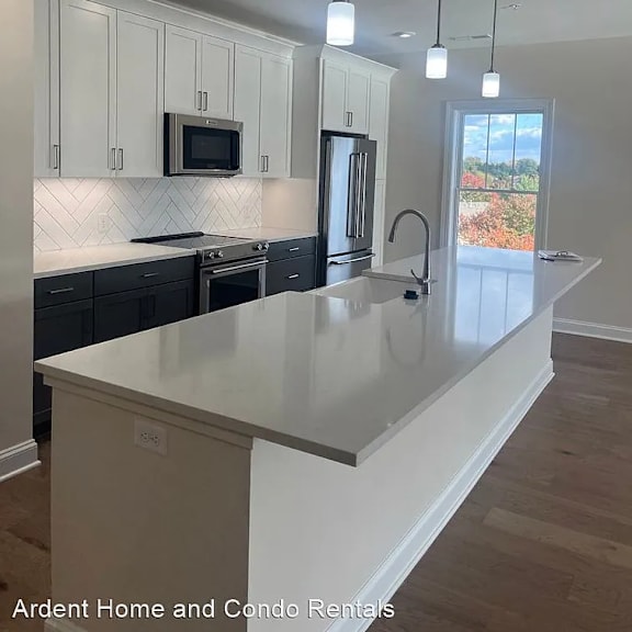 an updated kitchen with white cabinets and a white counter top