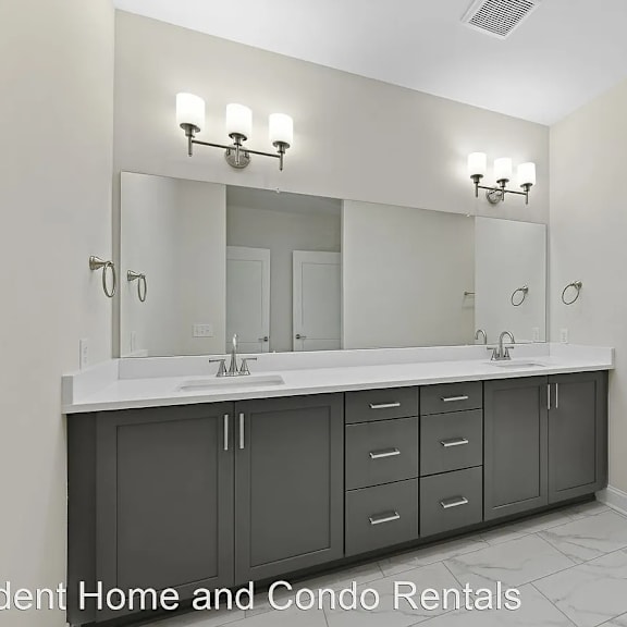 this master bathroom has a large vanity with two sinks and a shower