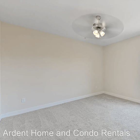 an empty bedroom with a ceiling fan and a window