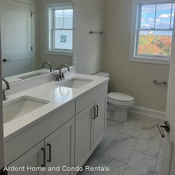a bathroom with white cabinets and a mirrored wall