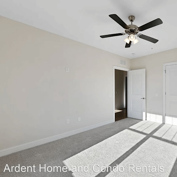 an empty living room with a ceiling fan and a closet