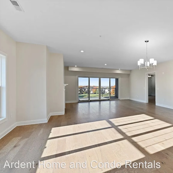 an empty living room with hardwood floors and white walls