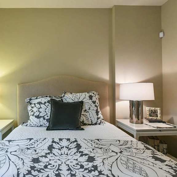 a bedroom with a bed and two tables with lamps