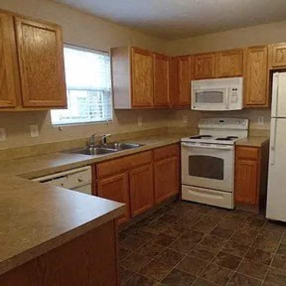 a kitchen with wooden cabinets and white appliances