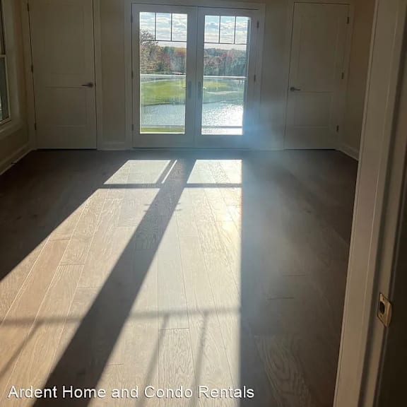 an empty living room with a ceiling fan and a window