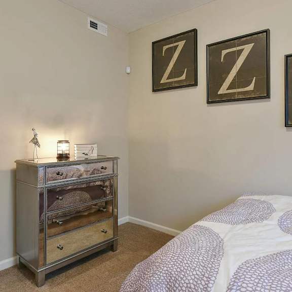 a bedroom with a bed and some pictures on the wall
