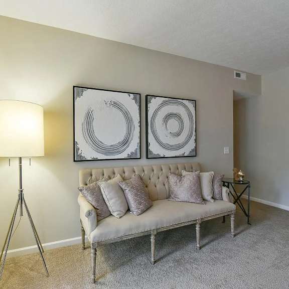 a living room with a couch and two paintings