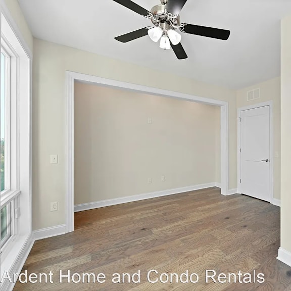 a empty room with a ceiling fan and a door