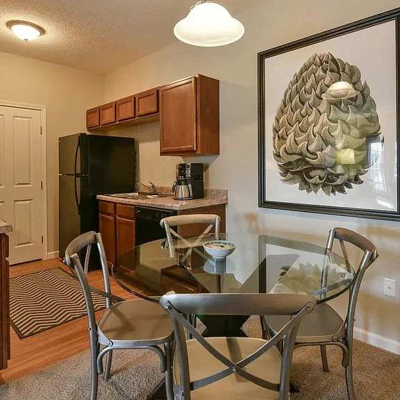 a kitchen and dining room with a glass table and chairs