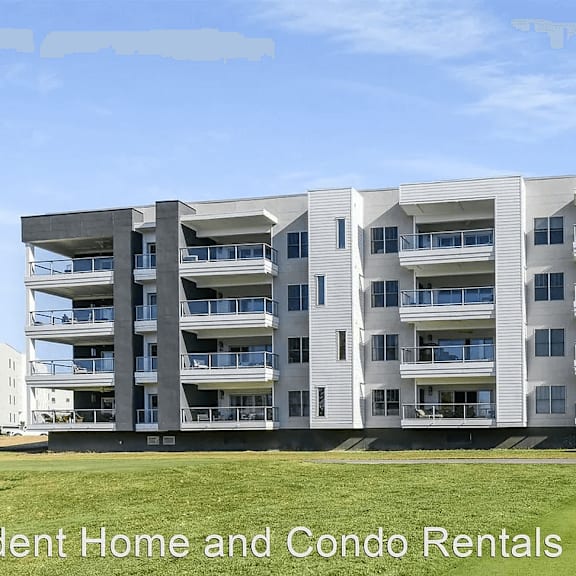 an apartment building with a lawn in front of it