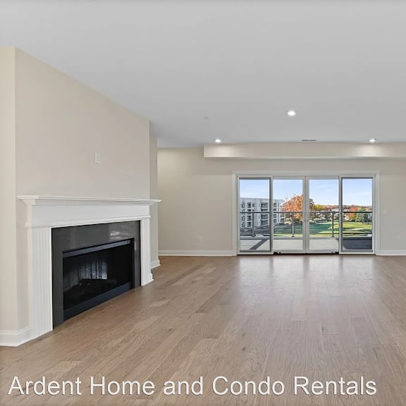a living room with a fireplace and a door to a balcony